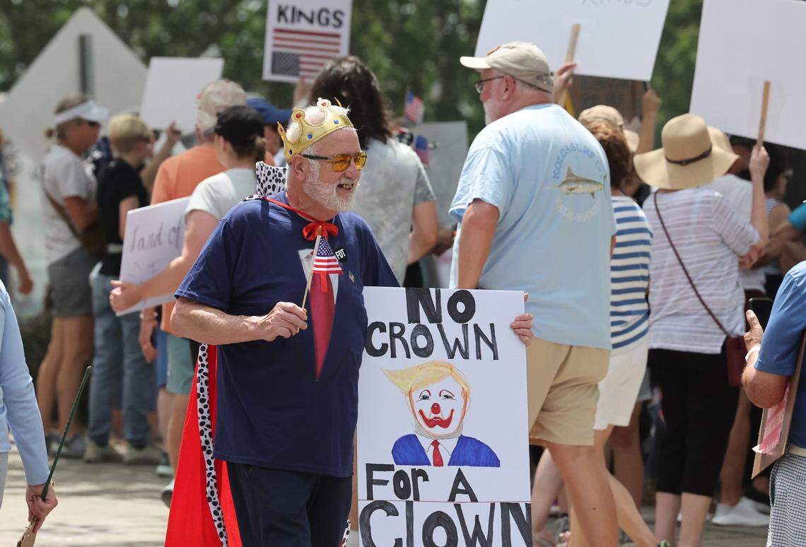A protester walks with a sign during the ‘No Kings’ protest against President Trump Saturday, June 14, 2025 in Rock Hill, S.C.