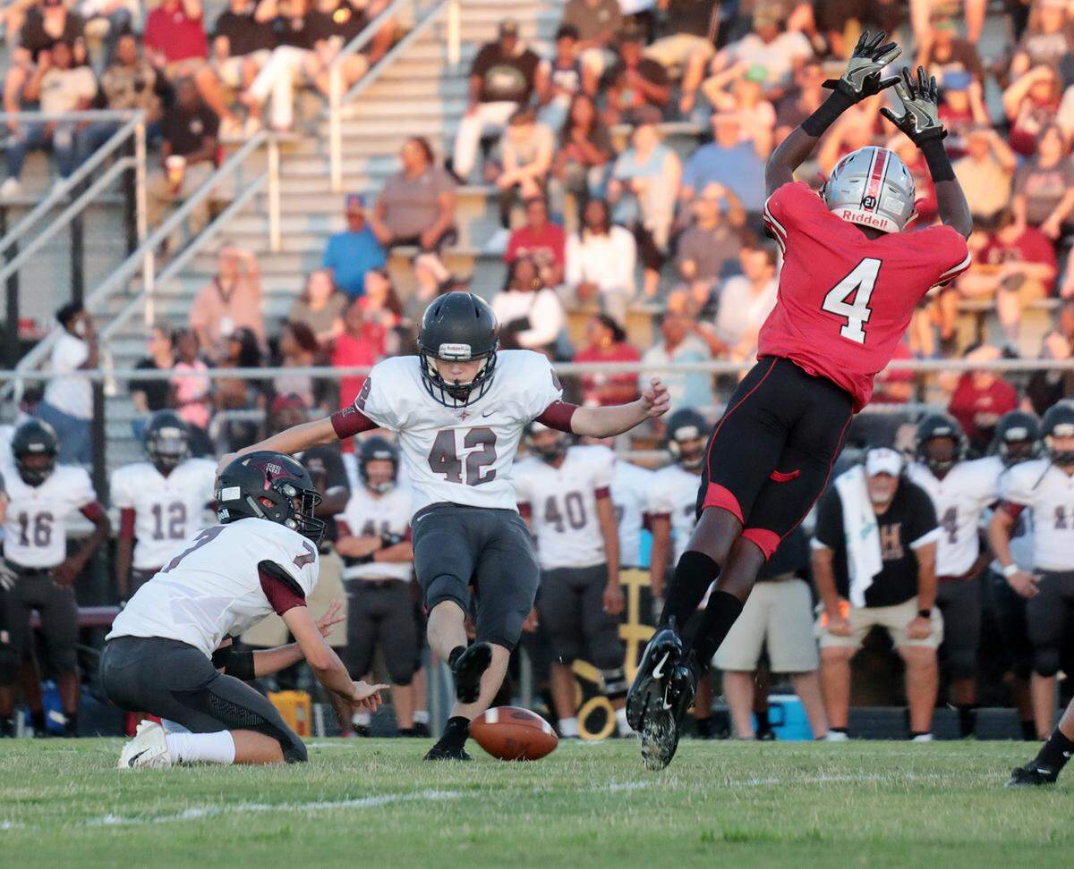 Rock Hill kicker Ethan Dutton (42) kicks the ball held by Jordan Thurmond (7) as South Pointe’s Jordan Mahoney tries to block.