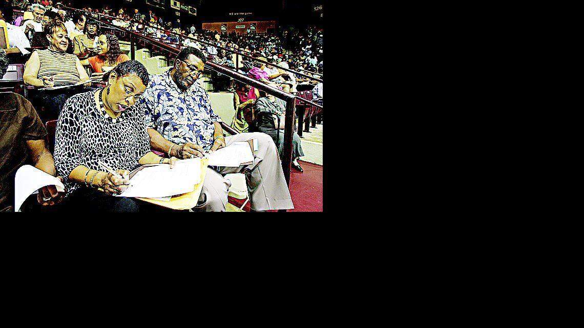 Doris and John Kilgore of Shelby, N.C., fill out forms during a meeting of former Celanese workers at the Winthrop Coliseum on Friday.