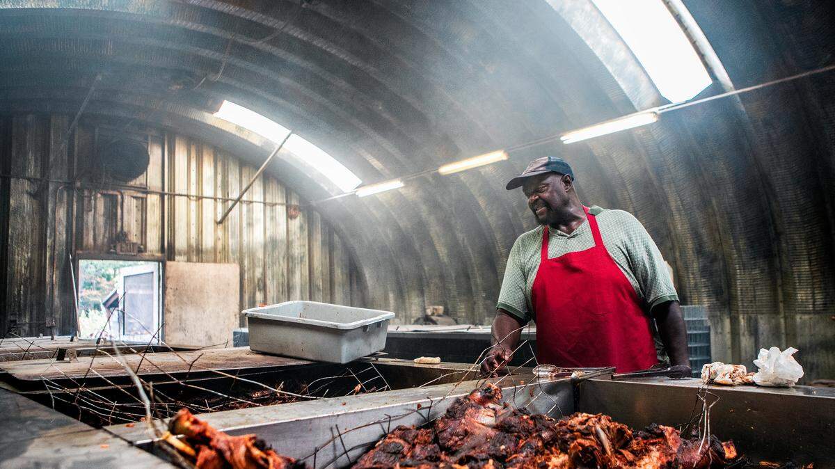 Sam Wilson checks on whole hogs at Scott's Bar-B-Q.