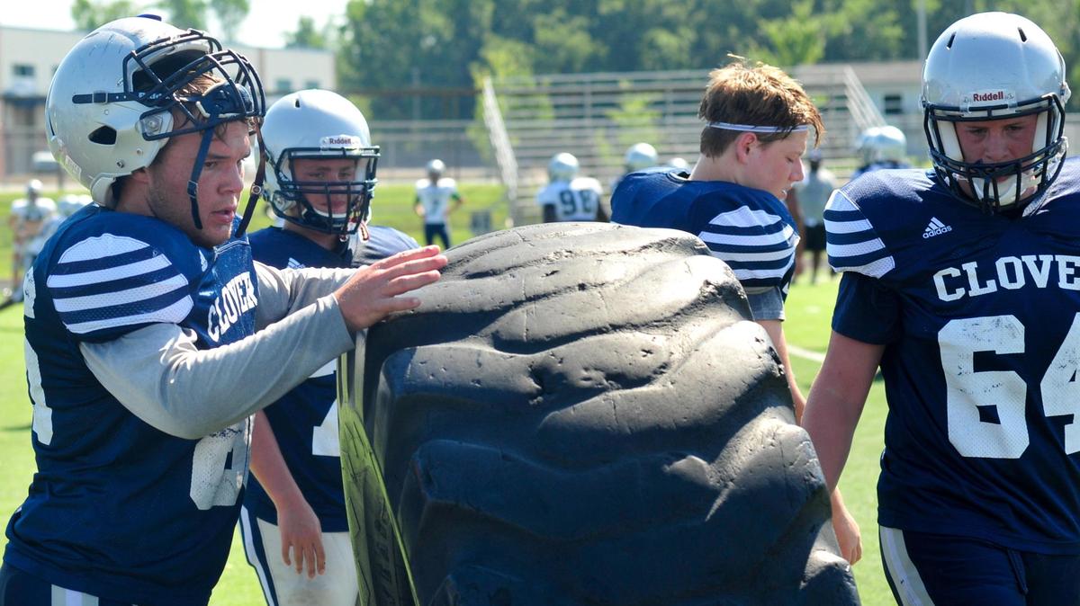 Clover’s Keith Collins lifts a tire during a conditioning drill at a morning practice last week. The team is mostly underclassmen and hopes to improve on 2017 in part by maintaining leads.