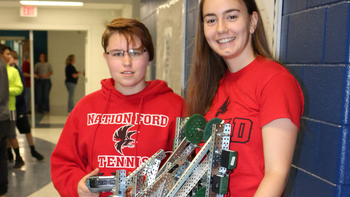 Nation Ford High School juniors Katy Kophazi, 17, left, and Anita Bitterli, 17, show off the robot they built for a robotics competition. Kophazi was recently selected for a pre-apprenticeship program at Bosch Rexroth in Charlotte.