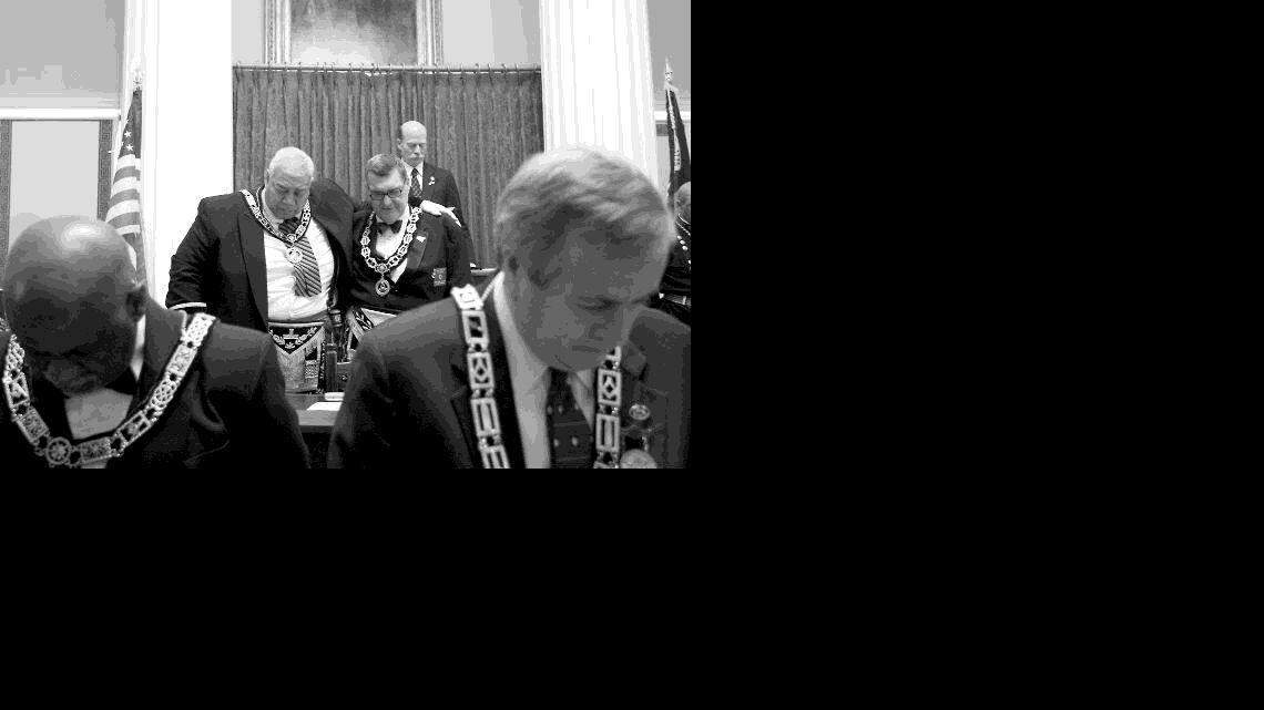 Milton Fitch Jr., left, and David Cash, right, are the Grand Masters of North Carolina's two Masonic organizations, which officially recognized each other on Friday after more than a century. They pray together before the start of a Brotherhood Celebration Program held at the State House in Raleigh.