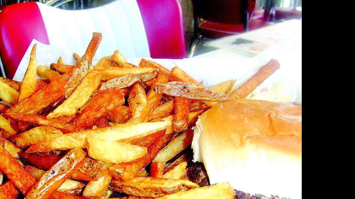 A Sonny's cheeseburger is served with a generous portion of fresh cut home fries and slaw.