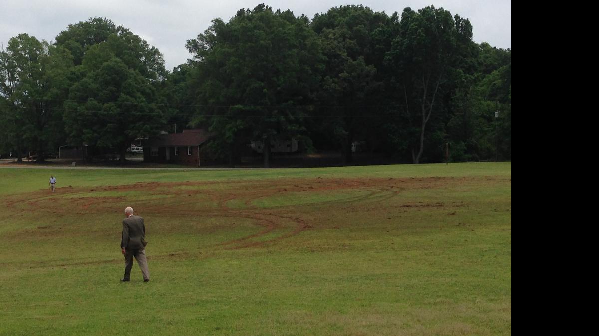 
Church members Gene Gardner, foreground, and Steve Newlin, background, survey damage caused by a reckless driver last weekend on the recreation field at Friendship United Methodist Church. Church officials hope two upcoming events will help cover the cost of repairing the field. 
