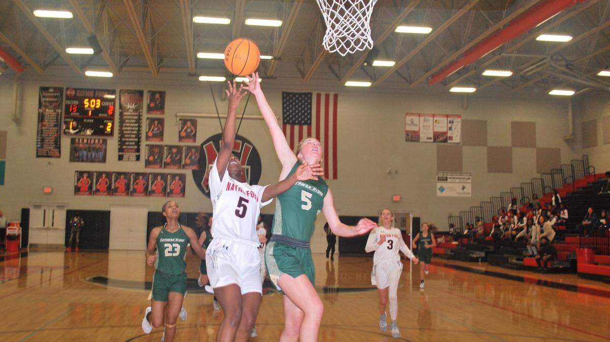 Nation Ford’s Denaundria Greene, left, shoots over a stretched out arm of Catawba Ridge’s Brielle Windisch during a recent game.