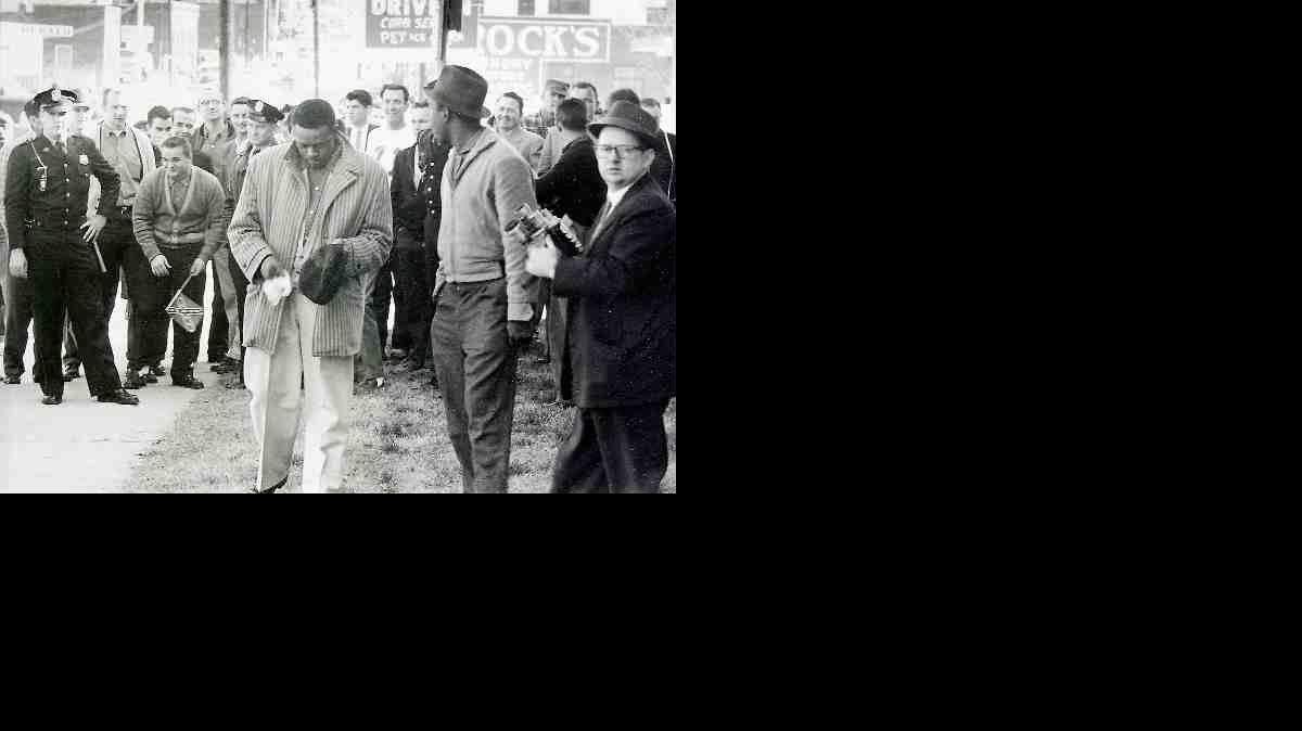 This photo from the Feb. 13, 1960, Evening Herald shows Bunt Gill wiping egg from his hat as police officers stand guard on West Main Street in Rock Hill. Elwin Wilson, now 72, is pictured in a white jersey over Gill's left shoulder. Wilson, who said he threw the egg, apologized to black protesters of segregation Friday at Old Town Bistro on East Main Street in Rock Hill.