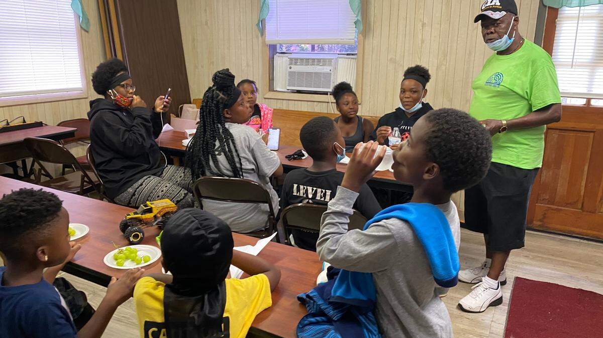 Children and volunteers enjoy a meal provided by the Historical Paradise Foundation.