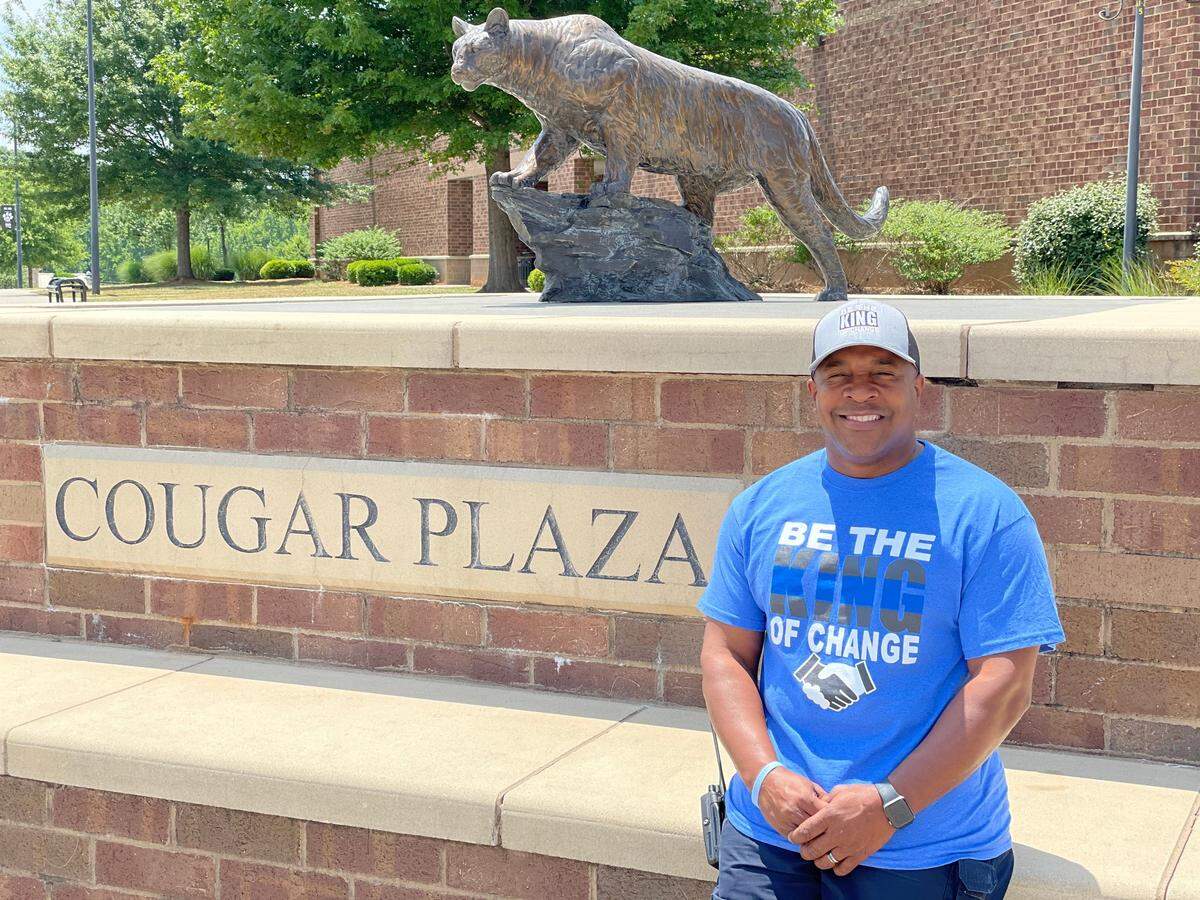 York police officer Pierre King stands in front of the Cougar Plaza wearing a shirt and cap that says “Be The King of Change,” a brand that has turned into a movement promoting unity between the public and law enforcement.