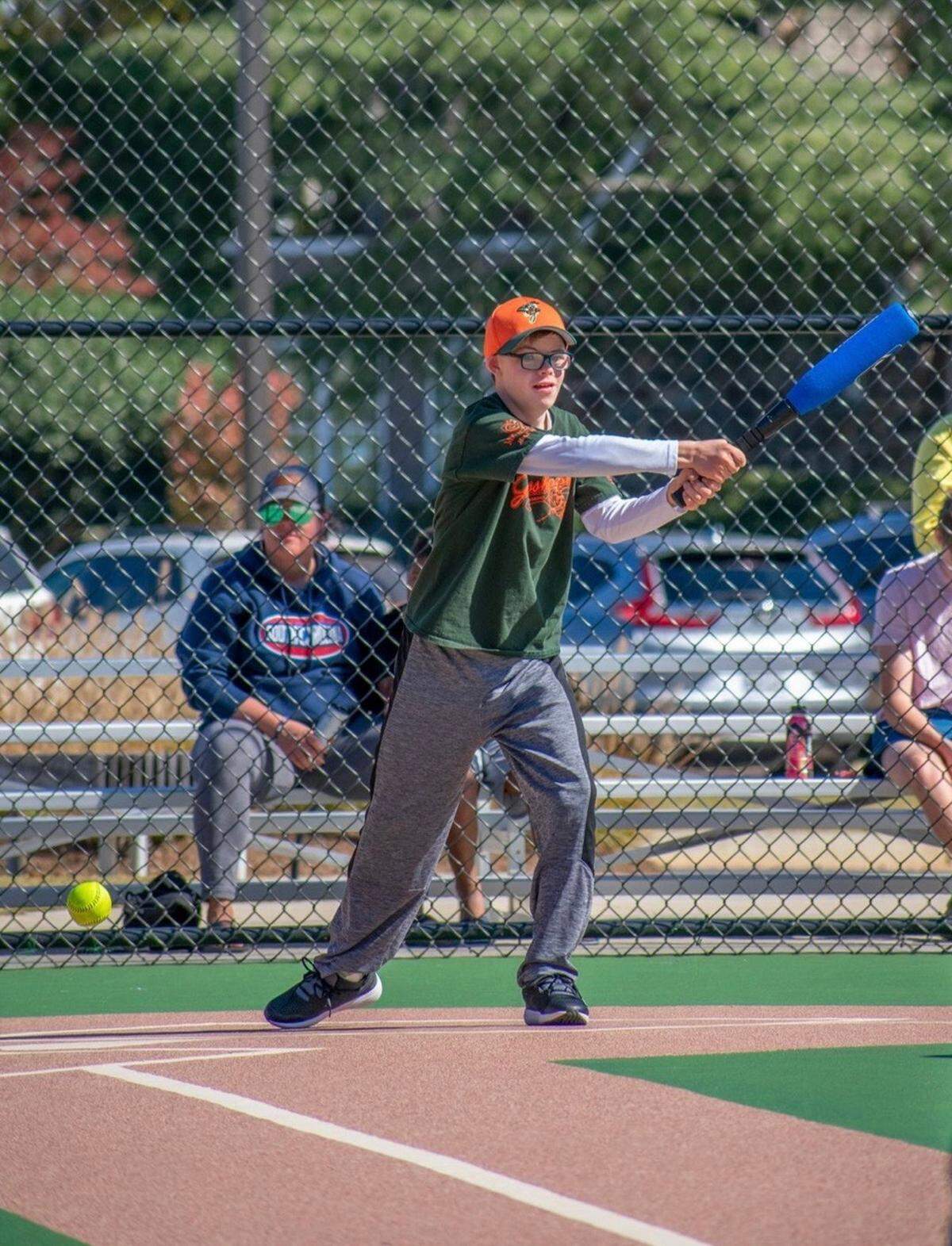 Hall Mitchell swings a bat in a Miracle League game.