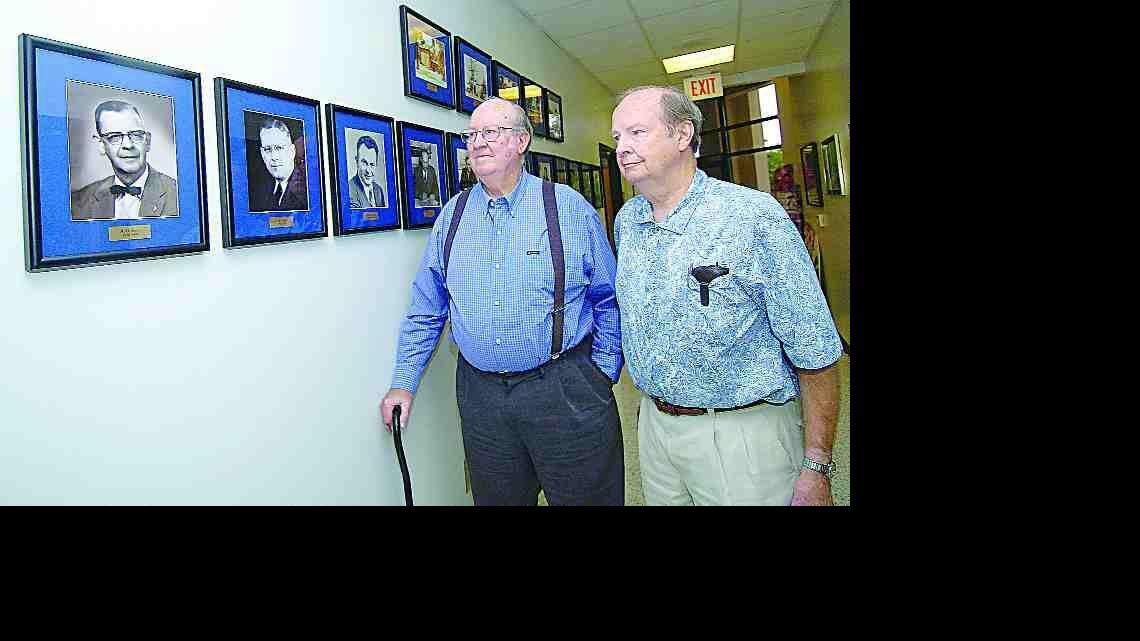 From left, brothers Oscar and Jim Jones look at a portrait, far left, of their father, A.O. Jones, a former principal at Fort Mill's high school. Photos of Fort Mill's former high school principals hang in the hallway at Fort Mill High.