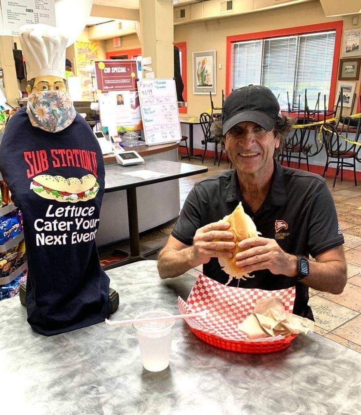 Longtime Winthrop tennis coach Cid Carvalho poses before eating a vegetarian sandwich at Sub Station II, a restaurant that is helping Winthrop alumni raise funds to ultimately reinstate the tennis programs.
