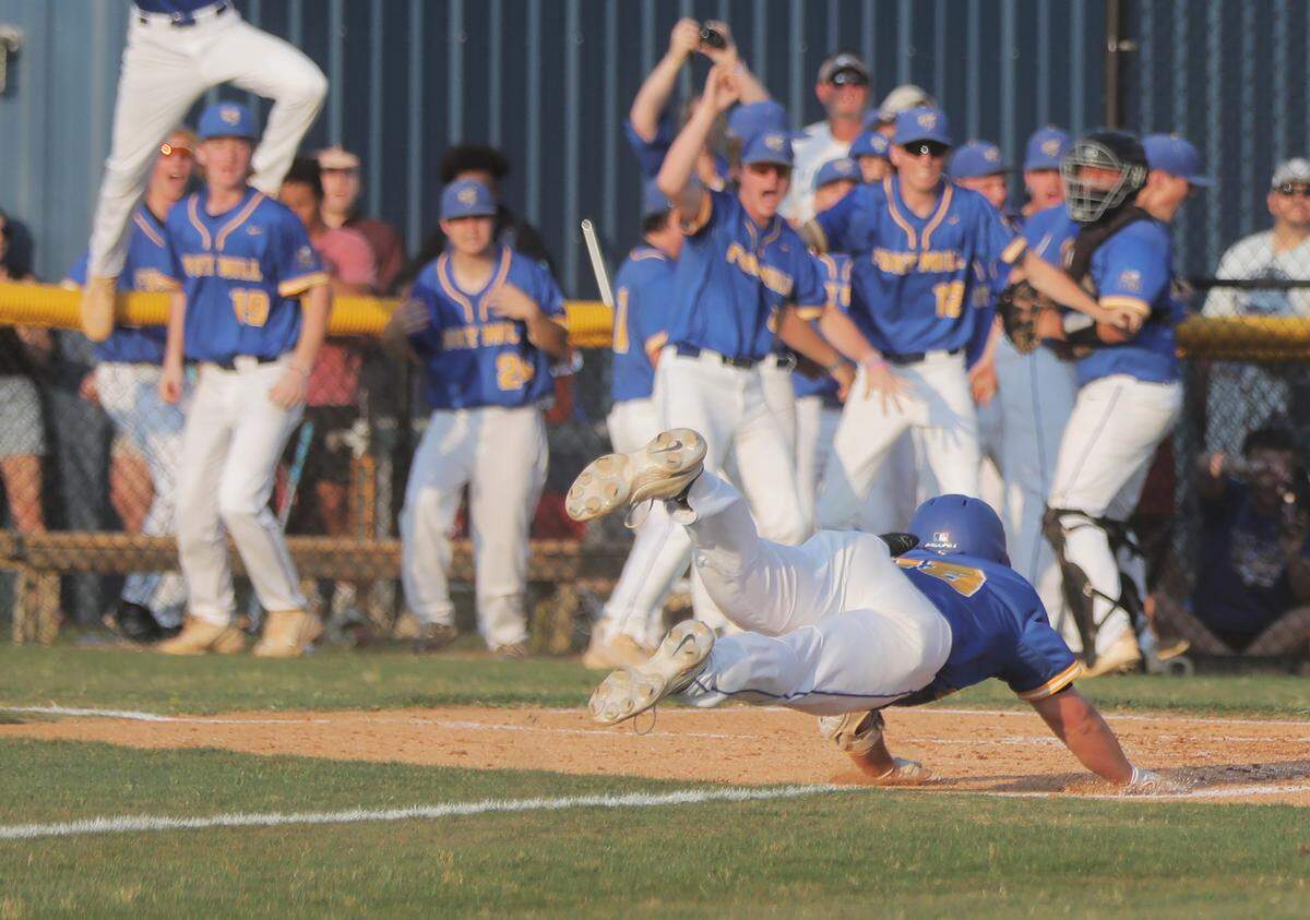Fort Mill’s Carter Blankinship dives into home plate Wednesday at Fort Mill High School as the team takes on Blythewood.