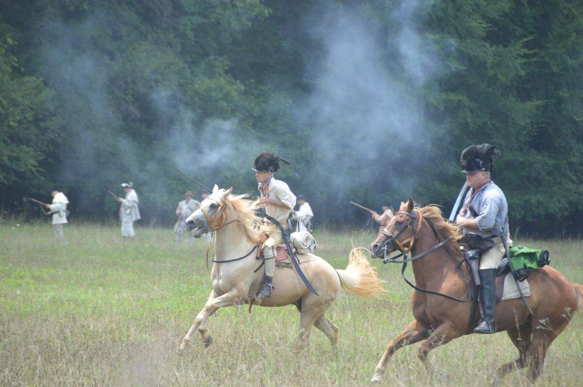 Riding a white horse, a volunteer reenactor portrays the loathed Capt. Christian Huck at Historic Brattonsville’s annual reenactment of the Battle of Huck’s Defeat
