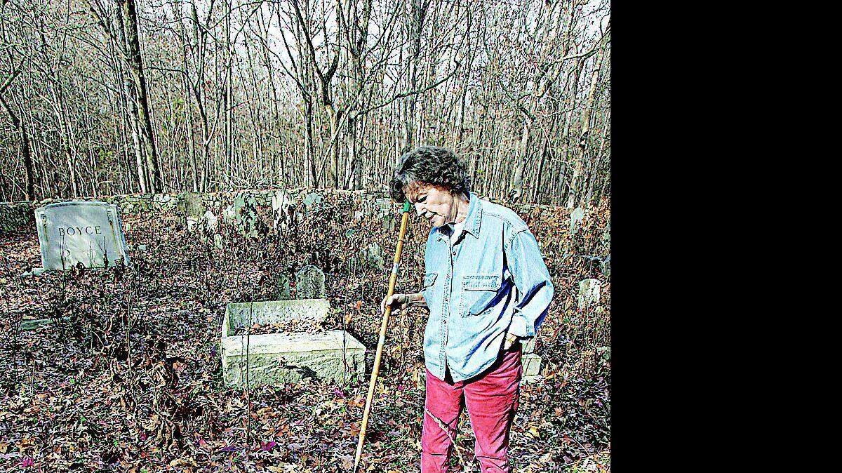 Above, Sylvia Galliher looks at a damaged tombstone in the Blackstock Cemetery between U.S. 21 and Interstate 77 in Fort Mill near the state line. Below, the Blackstock Cemetery is surrounded by a stone wall.