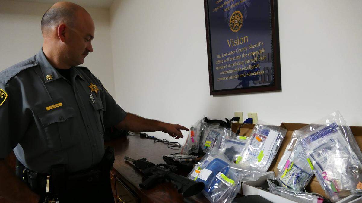 In this file photo, Maj. Matt Shaw with the Lancaster County Sheriff’s Office stands beside items seized in an operation. Law enforcement jobs are some of many available in York, Lancaster and Chester counties.