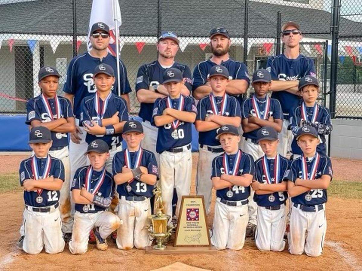 The 8U Fort Mill All-Stars mean mug together after the team’s World Series win in August 2021.