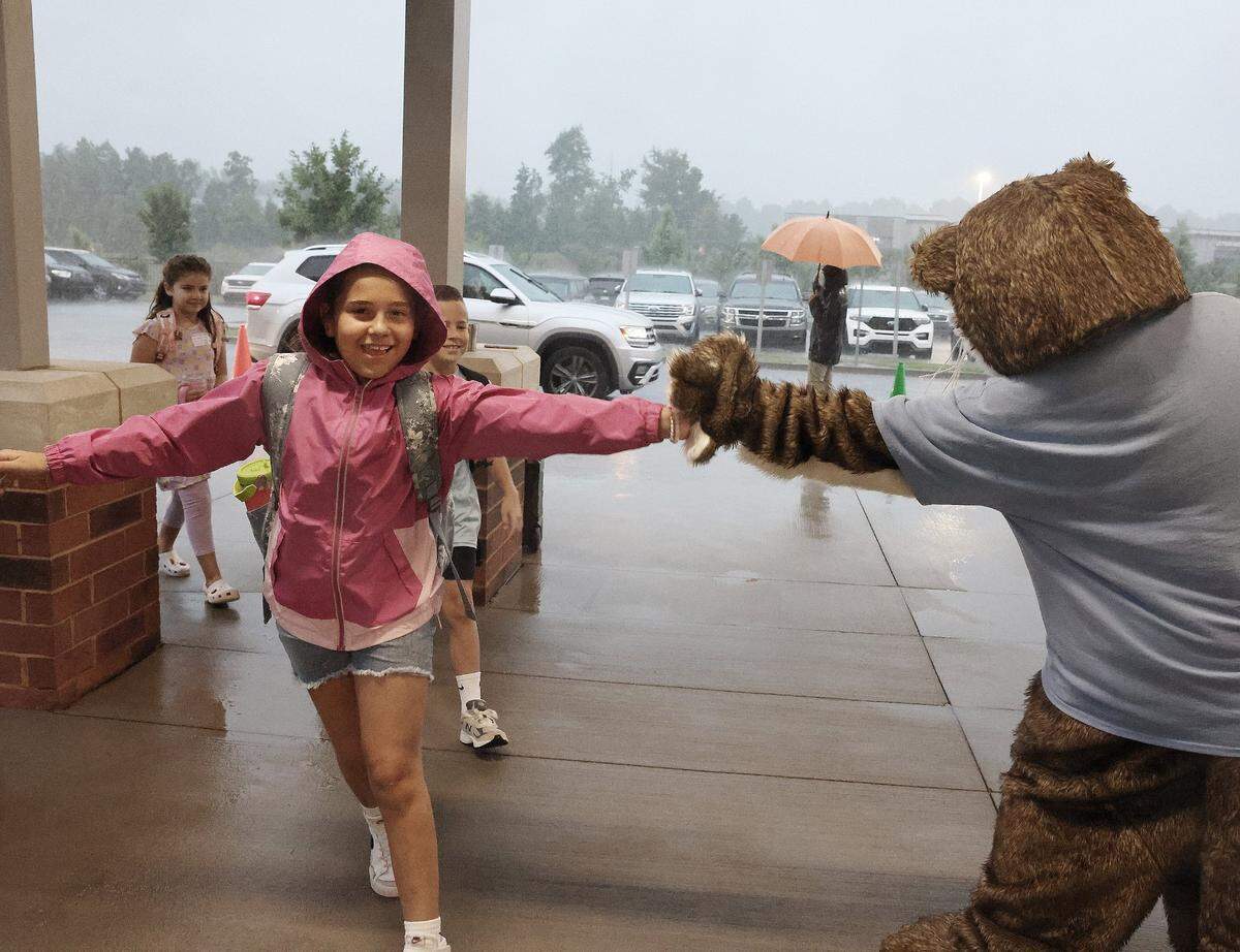 A child gives Ollie the Otter a high-five at the drop-off line at River Trail Elementary School in Fort Mill Thursday. Schools started in Fort Mill and Rock Hill on Aug. 8. Schools across York, Lancaster and Chester counties are planning for or building new schools as more students come to the area.
