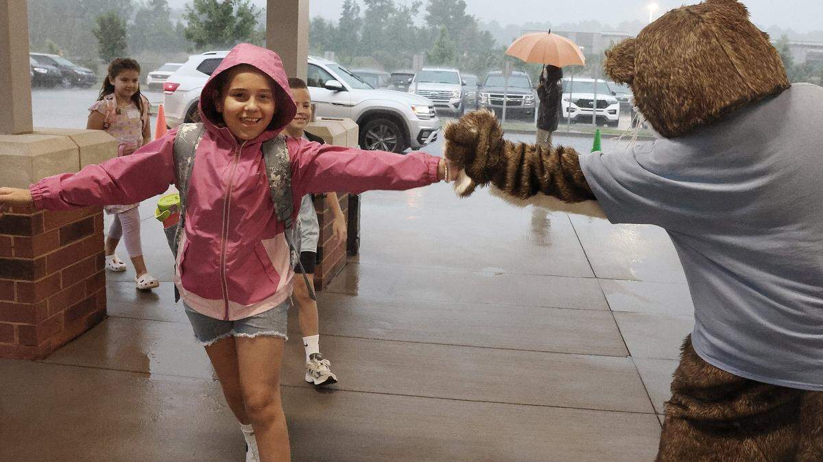 A child gives Ollie the Otter a high-five at the drop-off line at River Trail Elementary School in Fort Mill Thursday. Schools started in Fort Mill and Rock Hill on Aug. 8. Schools across York, Lancaster and Chester counties are planning for or building new schools as more students come to the area.