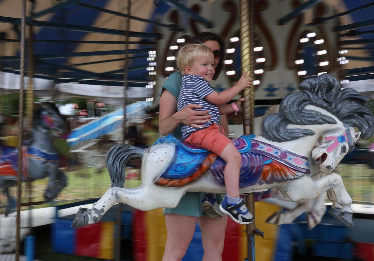Jessica Pettit and 2-year-old Dawson Pettit ride the Merry Go Round Friday, May 2, 2025 at Fort Mill’s Strawberry Festival.