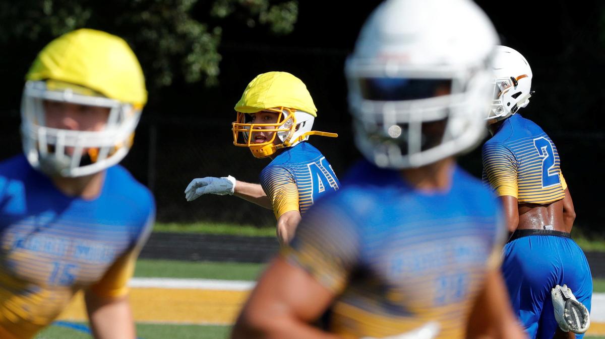 Fort Mill’s 40 Justin Crimm (center), playing defense, glances back to the quarterback as the Fort Mill Yellow Jackets practice last week.