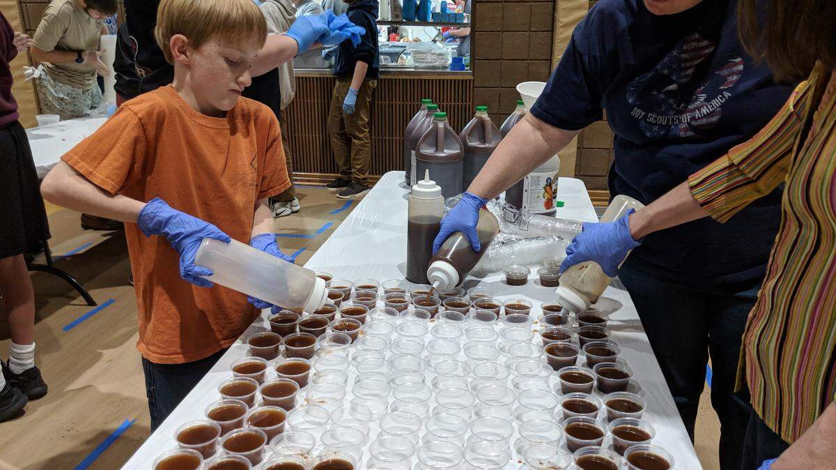Members of Boy Scout Troop 925 at St. John’s United Methodist Church in Rock Hill prepare cups of sauce for its eighth annual barbecue this weekend at the church. Plates available Friday and bulk items available for pick up Saturday.