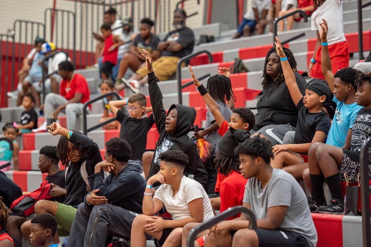 Children attending Derion Kendrick’s two-day youth football camp raise their hands to join a 3-on-3 basketball game at Rock Hill’s South Pointe High School.
