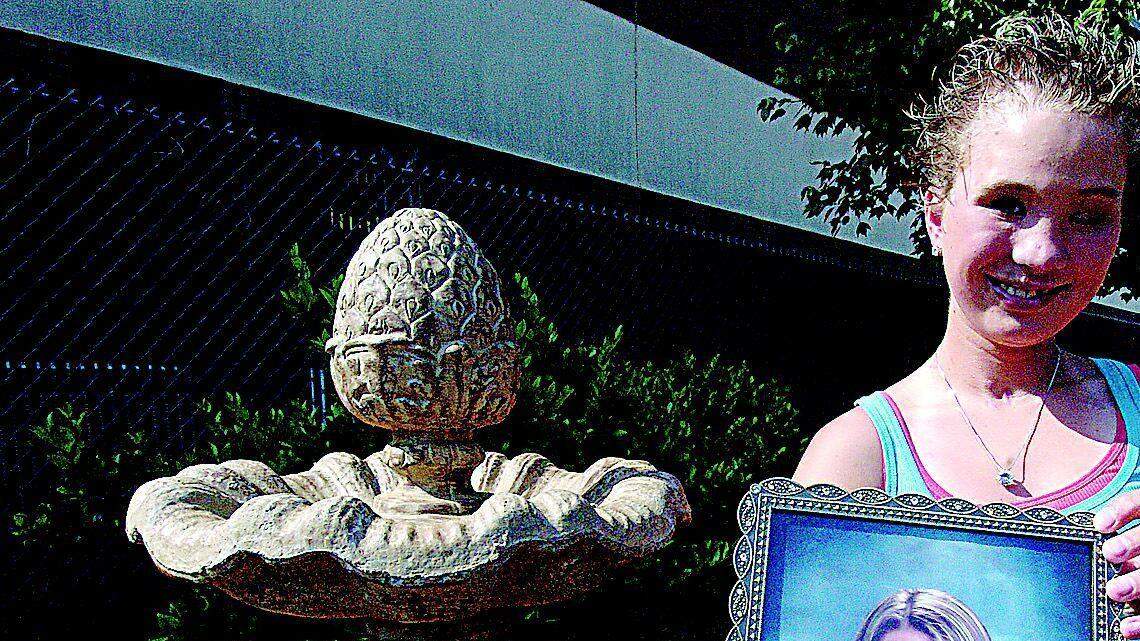 Presley Melton, 16, holds a photo of her friend, Lindsay Craven, who was killed last year in a car crash that also injured Melton. Neighbors of Craven donated money to buy a fountain and plaque in her memory at Rock Hill High School, shown above.
