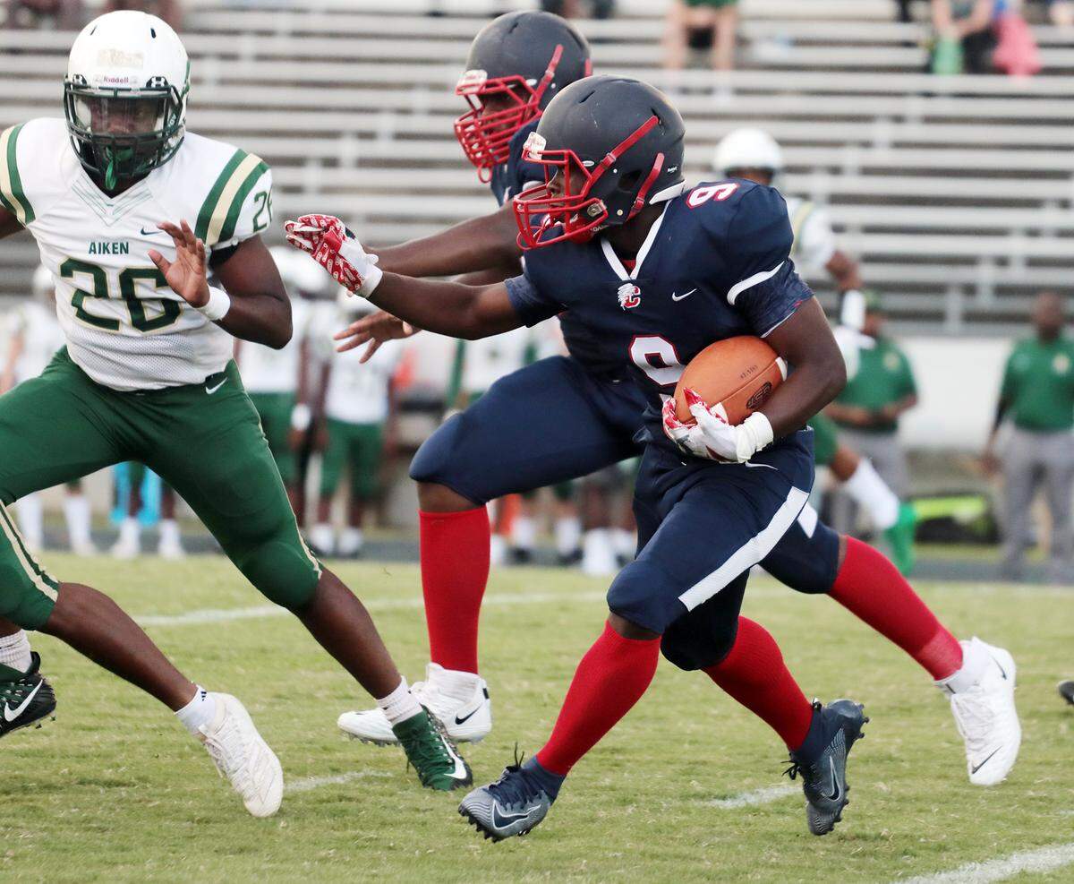 Chester’s Stan Mills carries the ball against Aiken’s Justin Whitt (26).