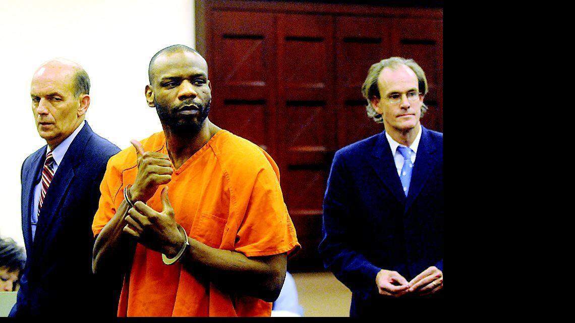 Bobby Lee Holmes gestures toward family members as he leaves the court room Saturday after pleading guilty to a 1989 murder.