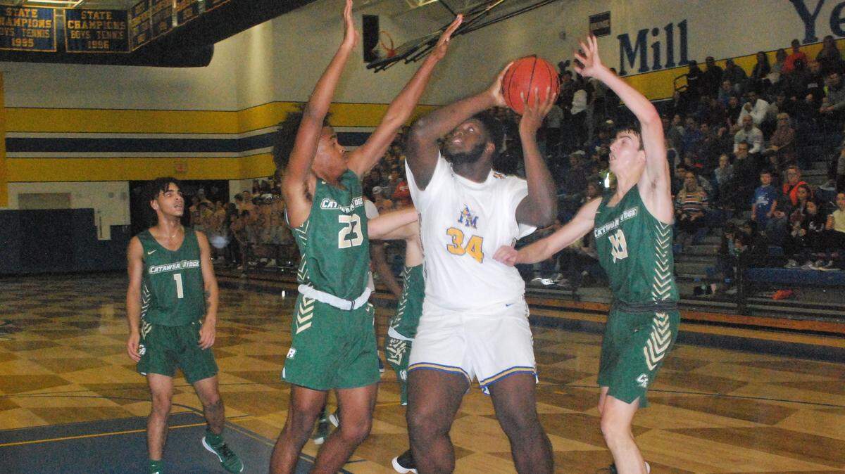 Fort Mill’s Jordan Herman, with the ball, shoots over two Catawba Ridge defenders on Friday, Dec. 6.