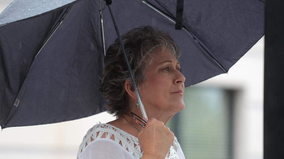 Joy McKay steps out into the rain Friday in downtown Rock Hill.