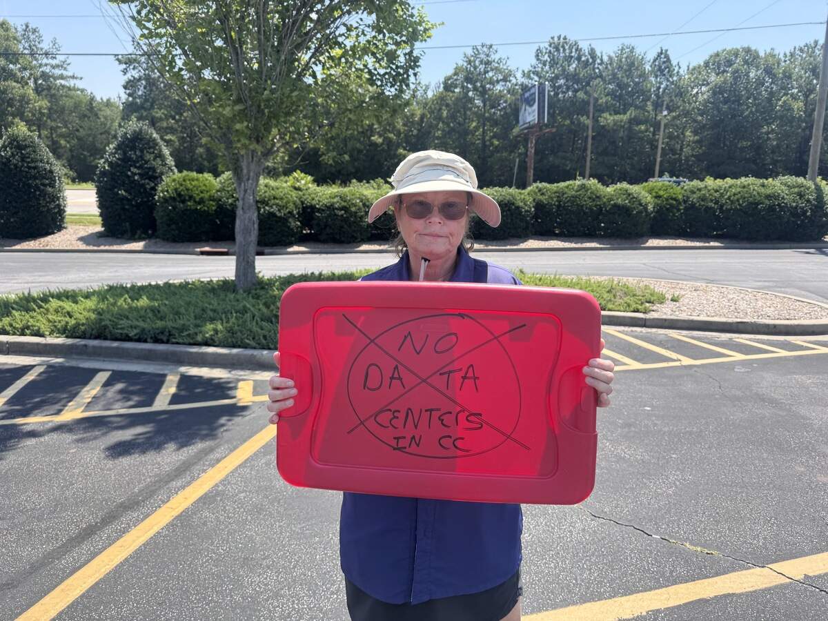 Gaye Jones holds a sign in protest of data center development Saturday, July 18, 2026, outside the Chester, South Carolina, Walmart Supercenter.