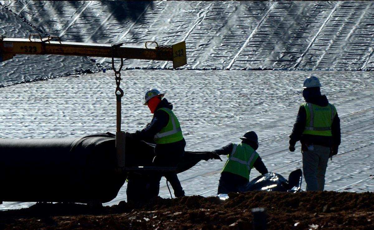 Workers add rolls of ash basin liner to a landfill site on the south side of the Allen Steam Station property. Open since 1957 the G. G. Allen Steam Station, a 1.140 GW coal-fired electricity generating facility, located in Belmont on Lake Wylie, is being decommissioned.