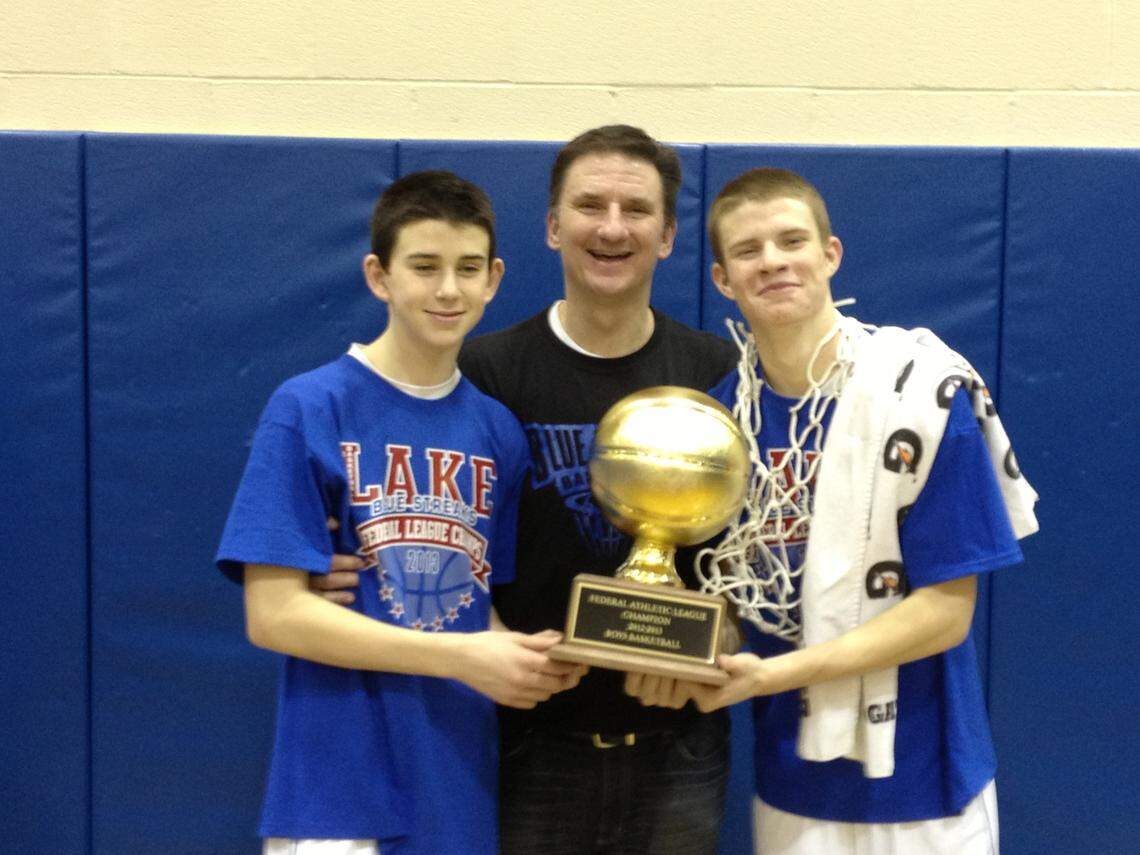 Chandler, left, poses with a Federal League Championship trophy his high school won when he was a freshman in 2014. He’s joined by his father, Bryan (middle), and brother, Chaese.