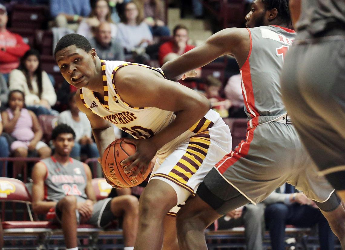 Winthrop’s D.J. Burns Jr. looks for an opening around Gardner-Webb’s Kareem Reid Saturday as the Eagles take on the Bulldogs at the Winthrop Coliseum.