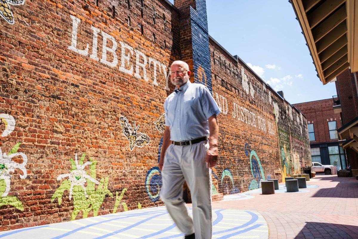 Stephen Turner, a member of the board or directors of historic rock hill, walks down the Freedom Walkway in Rock Hill, S.C. The Freedom Walkway is an alleyway in the city of Rock Hill that showcases and celebrates various people in Rock Hill and the greater Rock Hill area who have fought for equal rights for all. The first people to be celebrated in the freedom walkway were the ‘Friendship Nine’, a group of nine African American cival rights demonstrators who protested segregation in Rock Hill by sitting in on a restaurant, they were then arrested and sentenced to 30 days of labor at the county prison farm. Every year 3-4 new people’s names and stories are shared and added to the freedom walkway’s brick engravement at the end of the walkway, with each new name being announced every November.&nbsp;