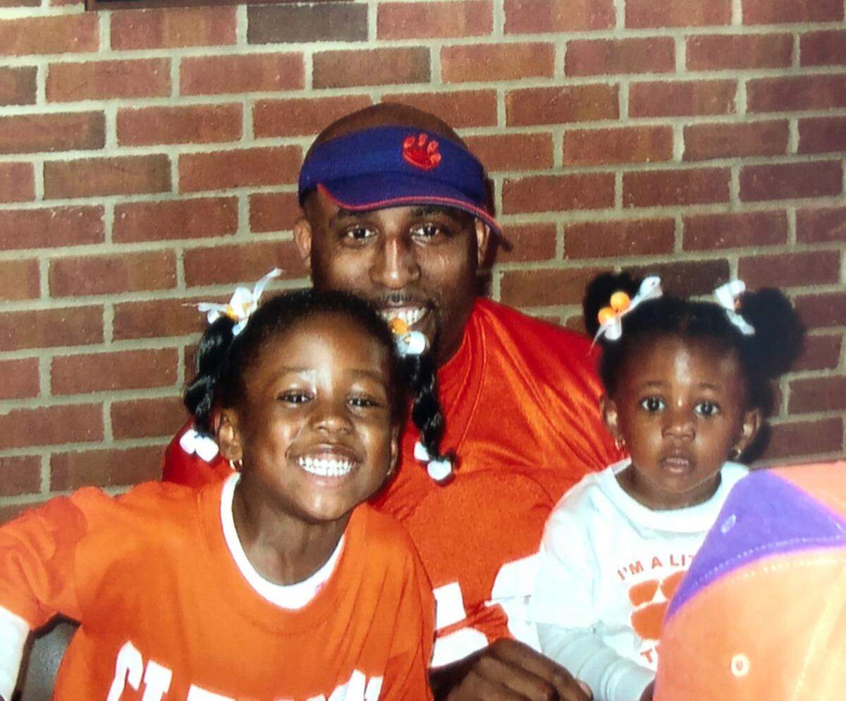 Jada, left, poses for a picture with her father, Tim, and sister, Layla.