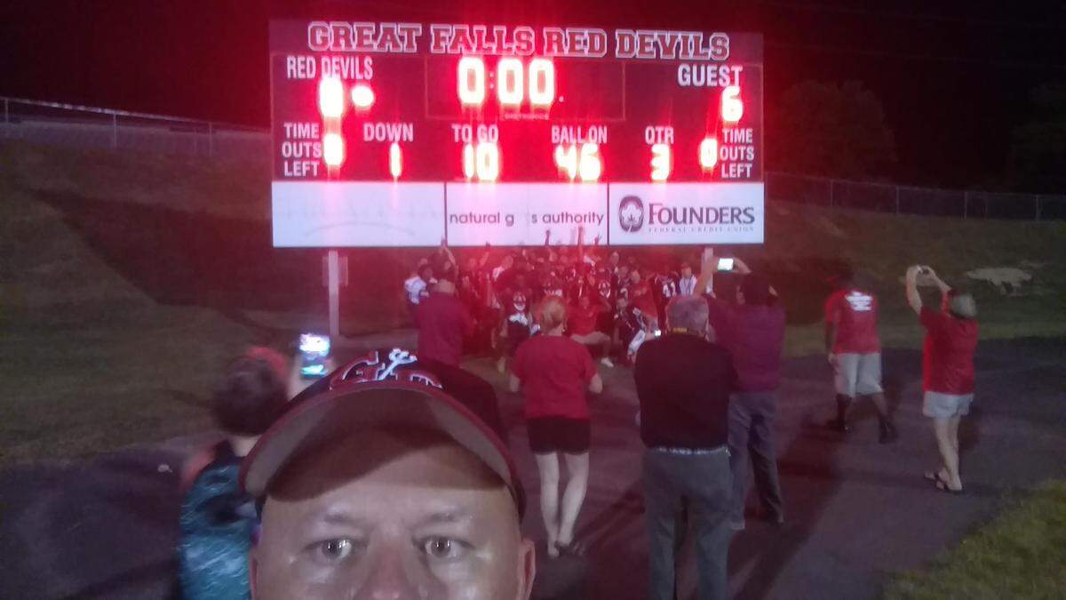 Great Falls coach Scotty Steen snapped a selfie in front of the scoreboard Aug. 17, 2018 after his Great Falls Red Devils snapped a 19-game losing streak with an 8-6 win over C.A. Johnson.
