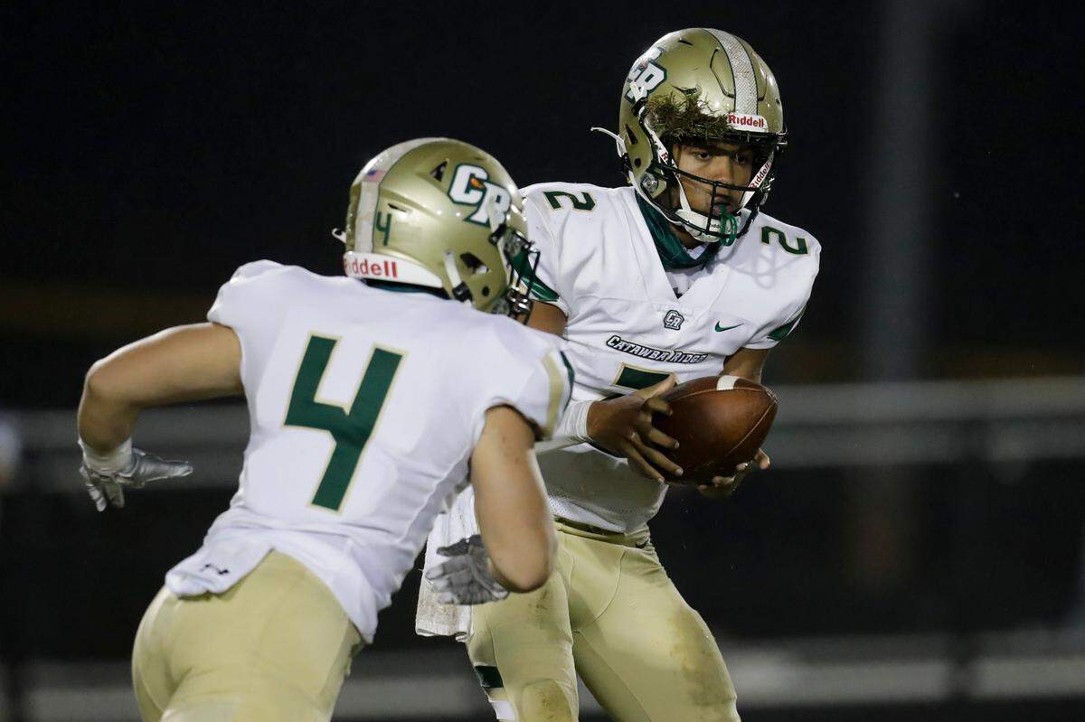 Catawba Ridge quarterback #2 Jadyn Davis hands the ball to #4 Henry Bowen in early play as South Pointe hosts Catawba Ridge in Friday night varsity football.