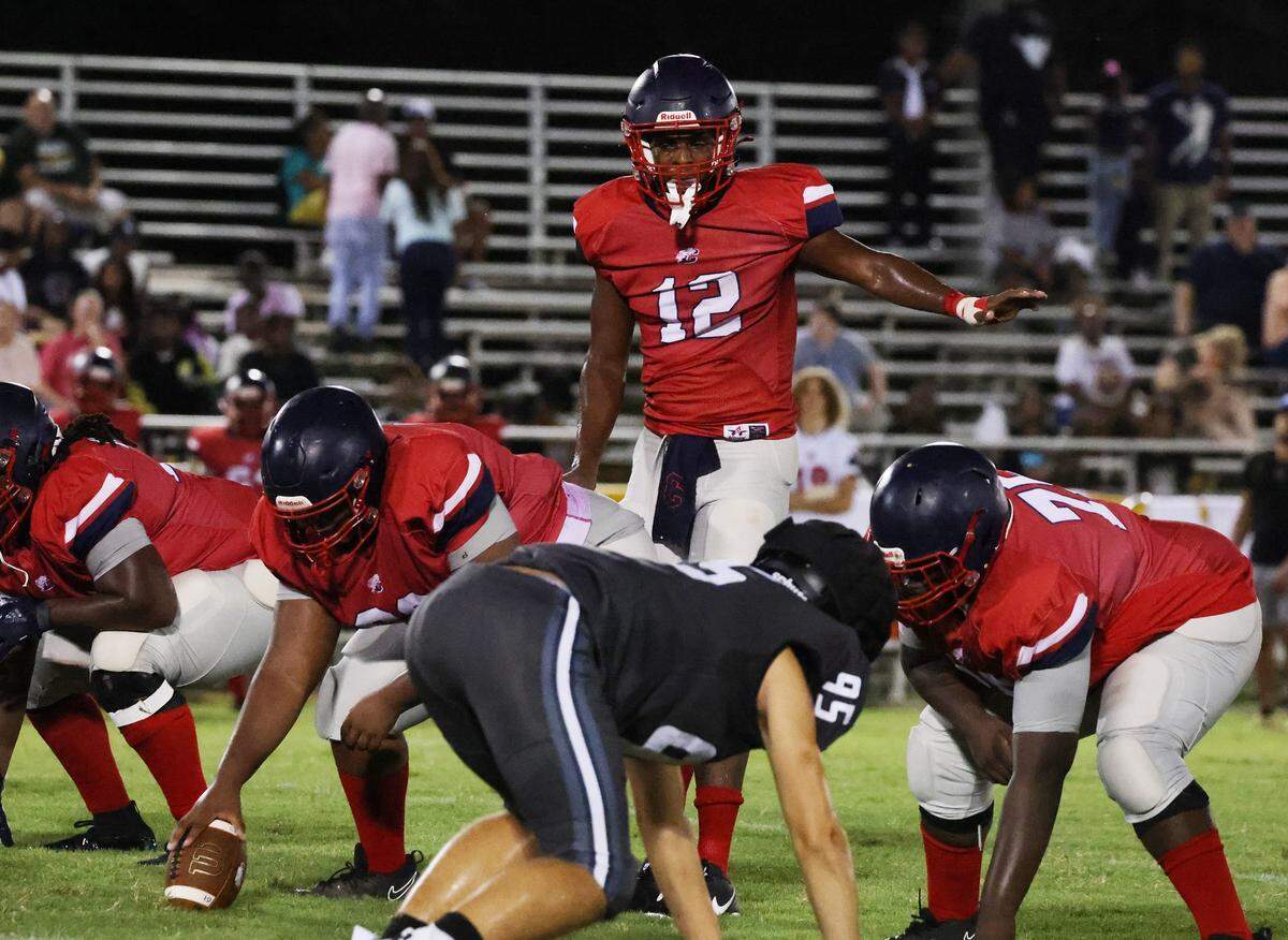 Trooper Floyd (12, red) stands tall as he sets the offense in a scrimmage against York on August 9.