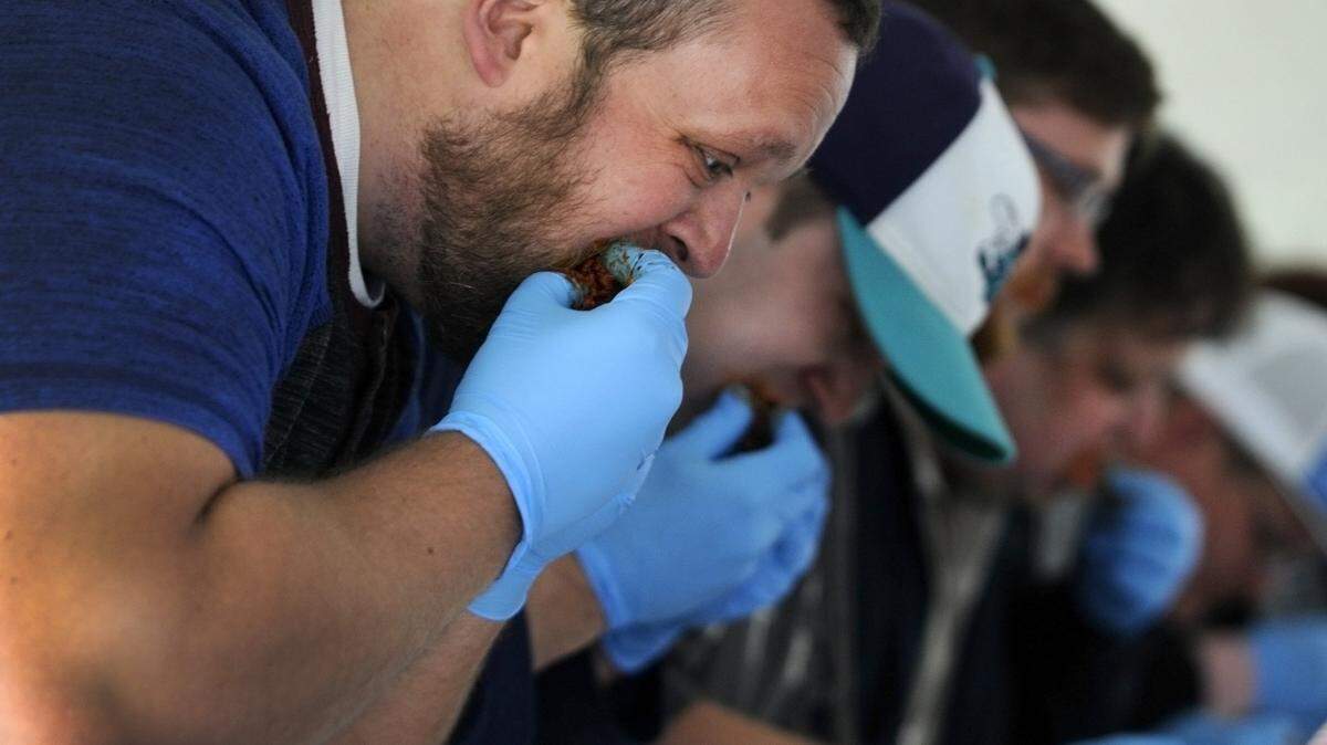 Keith Ashby of Weddington, N.C. competes in a hot wing eating contest at the 2017 Strawberry Festival in Fort Mill. Ashby won first place.