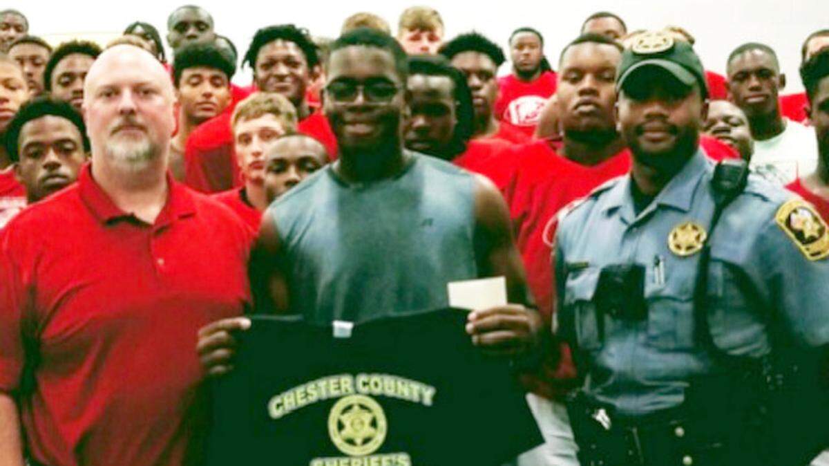 Chester County Sheriff Max Dorsey (front left) poses for a picture with Jeremiah Days Jr. (front middle) after awarding the Chester High School football player with the first-ever “Guardian of the Week” award.