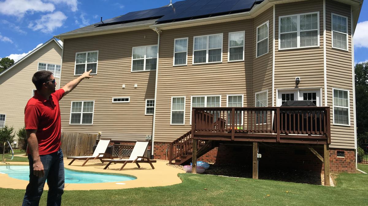 Fort Mill resident Steve Ogden points to the solar panels on his roof. After rebates and tax credits, he had the panels installed at a fraction of the cost and they’re producing more energy than he expected.