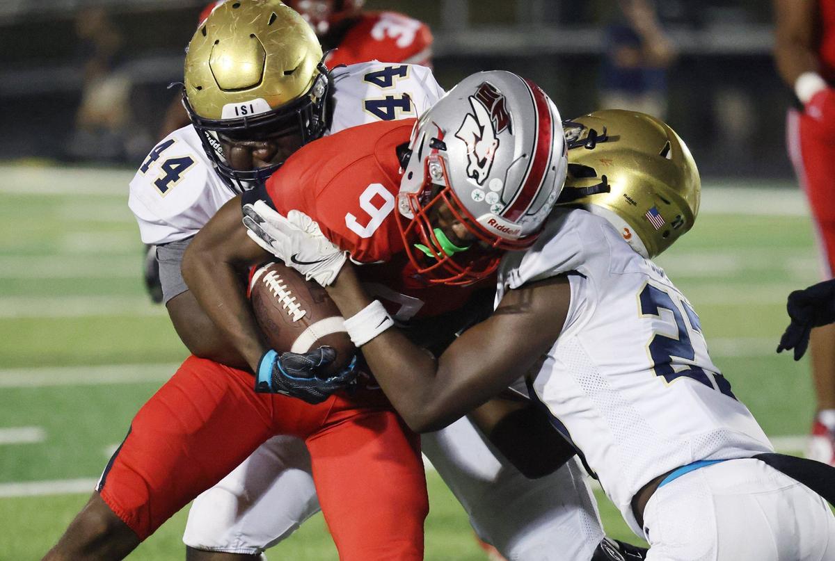 South Pointe’s Dailan Duncan is brought down by Spartanburg’s JayUndr’a Cohen-Foster (44) and C.J. Woodruff Friday in Rock Hill.