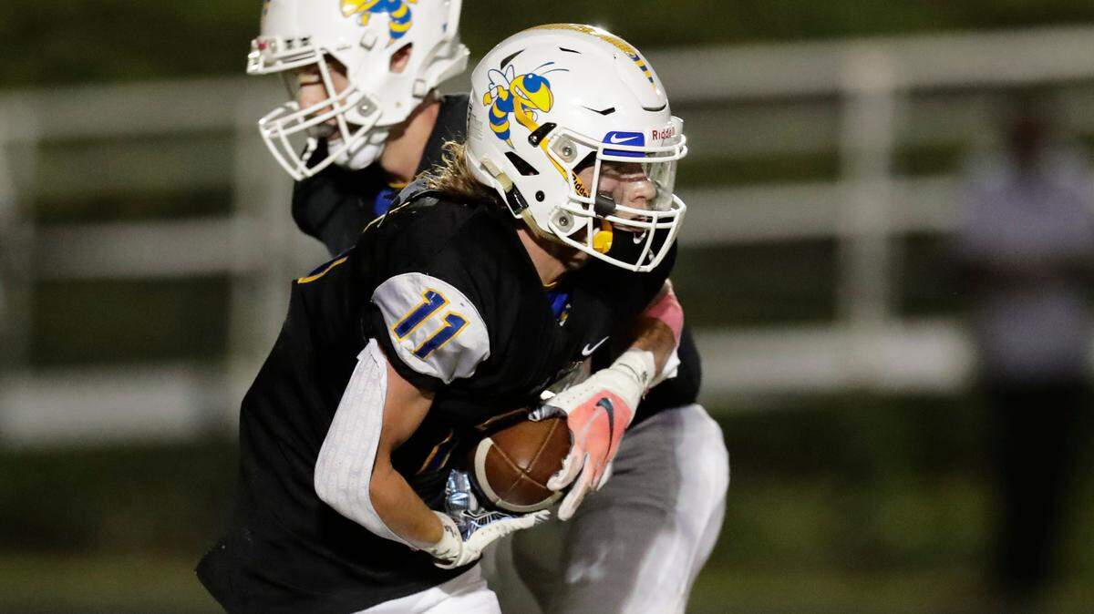 Fort Mill’s (11) Joshua Sturgeon takes a hand off in early play as Fort Mill hosts Nation Ford in a cross town football rivalry Friday, October 1, 2021.