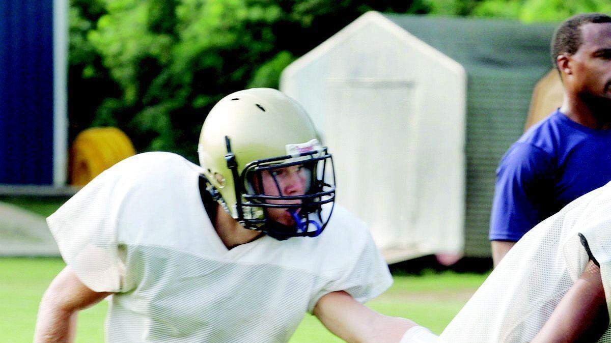 Westminster Catawba quarterback Evan Andert hands off to Brodrique Moore at practice Tuesday. Coach Michael Scurlock looks on in the background.