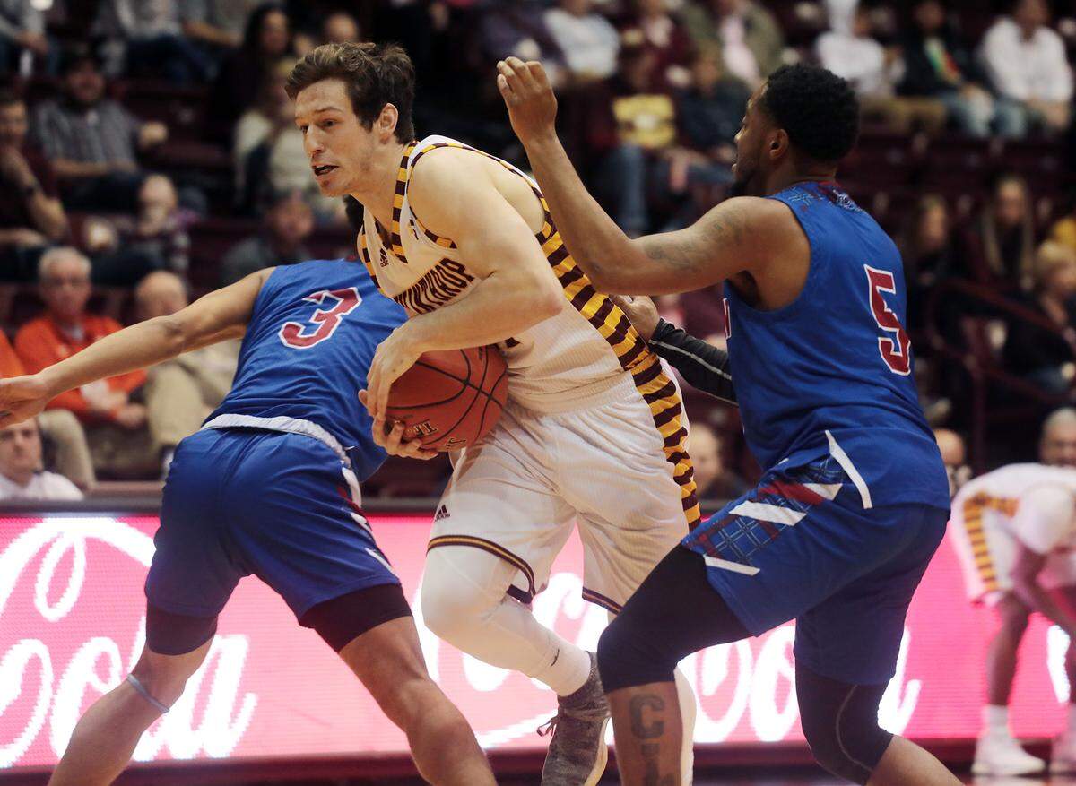Winthrop’s Kyle Zunic heads to the basket around Presbyterian’s Romeo Crouch (3) and Davon Bell in the 2018-19 season.