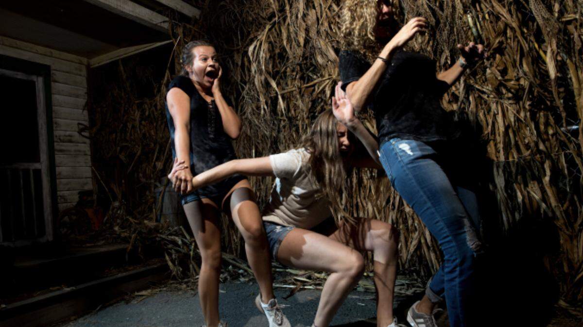 Carowinds visitors in a haunted maze, part of the Scarowinds event. The park will be closed temporarily due to Tropical Storm Ian.