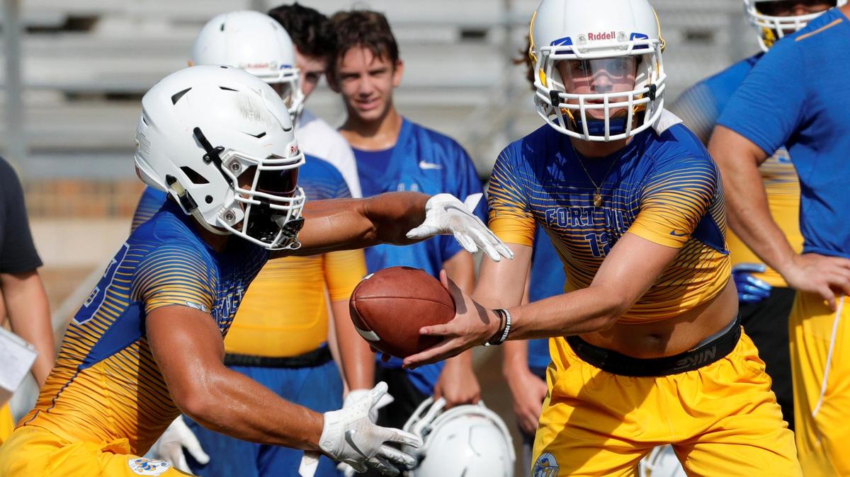 Quarterback Dylan Helms hands the ball off to Sebastian Lach as the Yellow Jackets take the practice field for the 2018 season Saturday. Helms is challenging returning starter JT Marr for the top spot.
